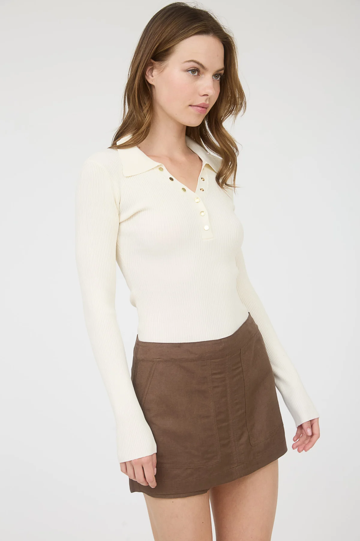 Blusa tipo polo con botones dorados y textura acanalada