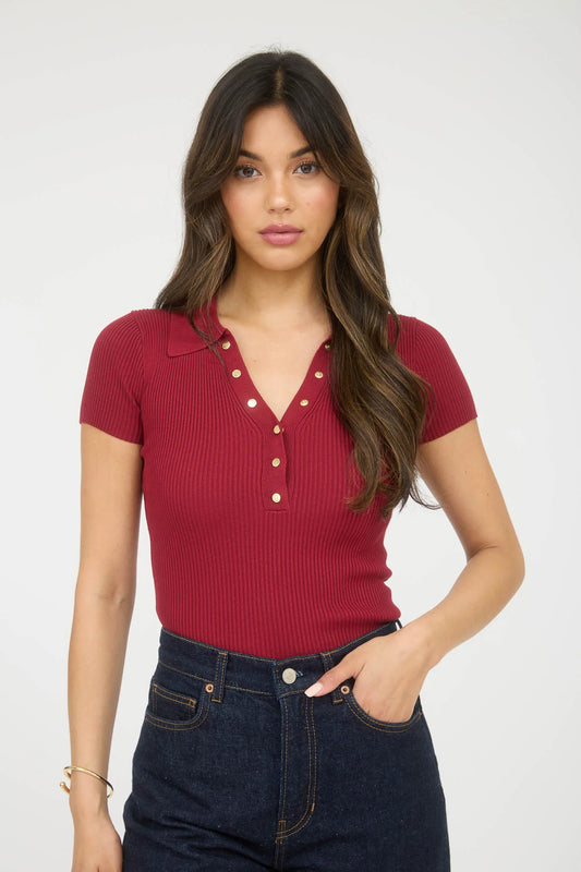 Blusa tipo polo stretch con botones dorados y textura acanalada