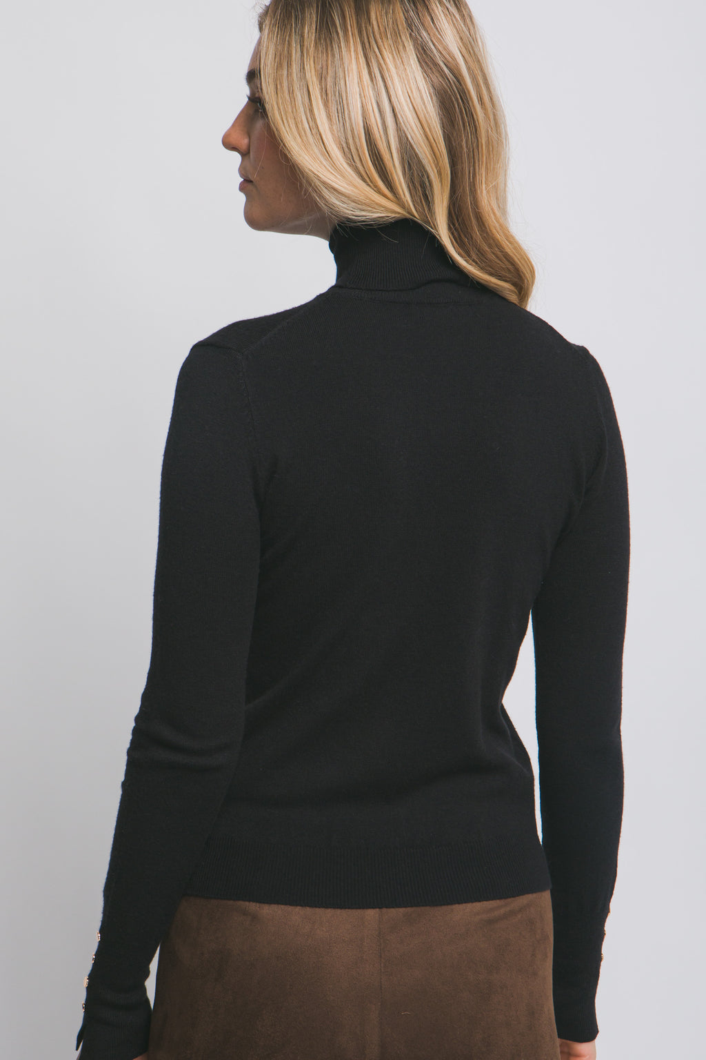 Blusa de punto con cuello alto y botones metálicos