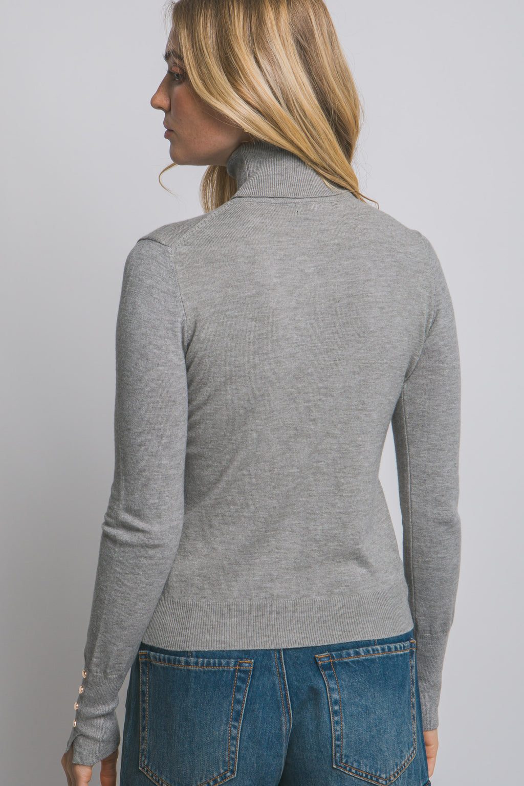 Blusa de punto con cuello alto y botones metálicos