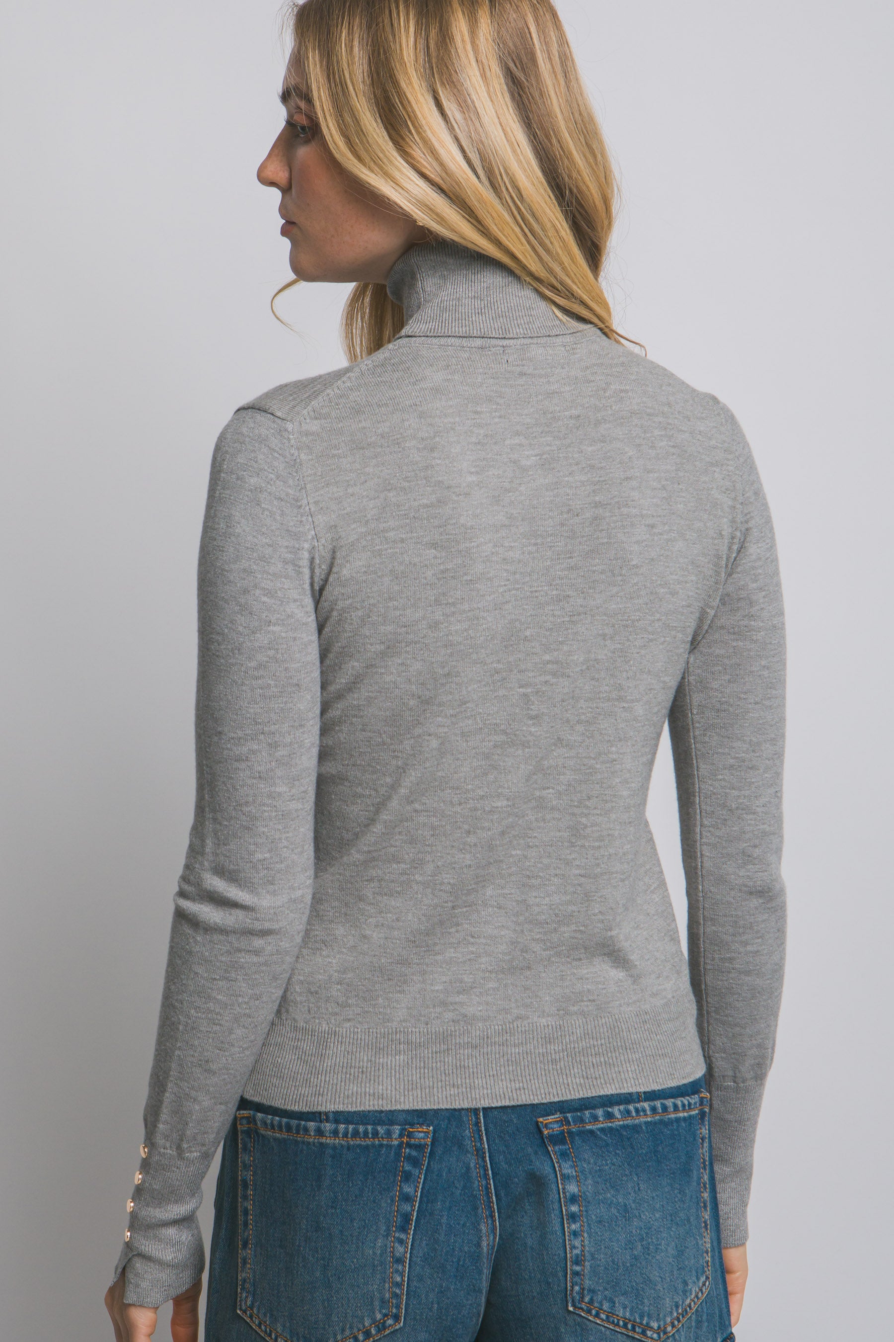 Blusa de punto con cuello alto y botones metálicos