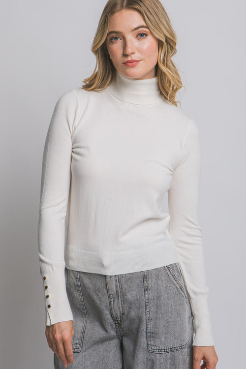 Blusa de punto con cuello alto y botones metálicos