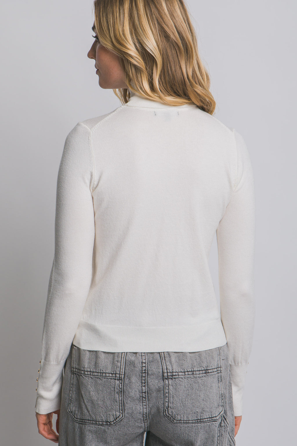 Blusa de punto con cuello alto y botones metálicos