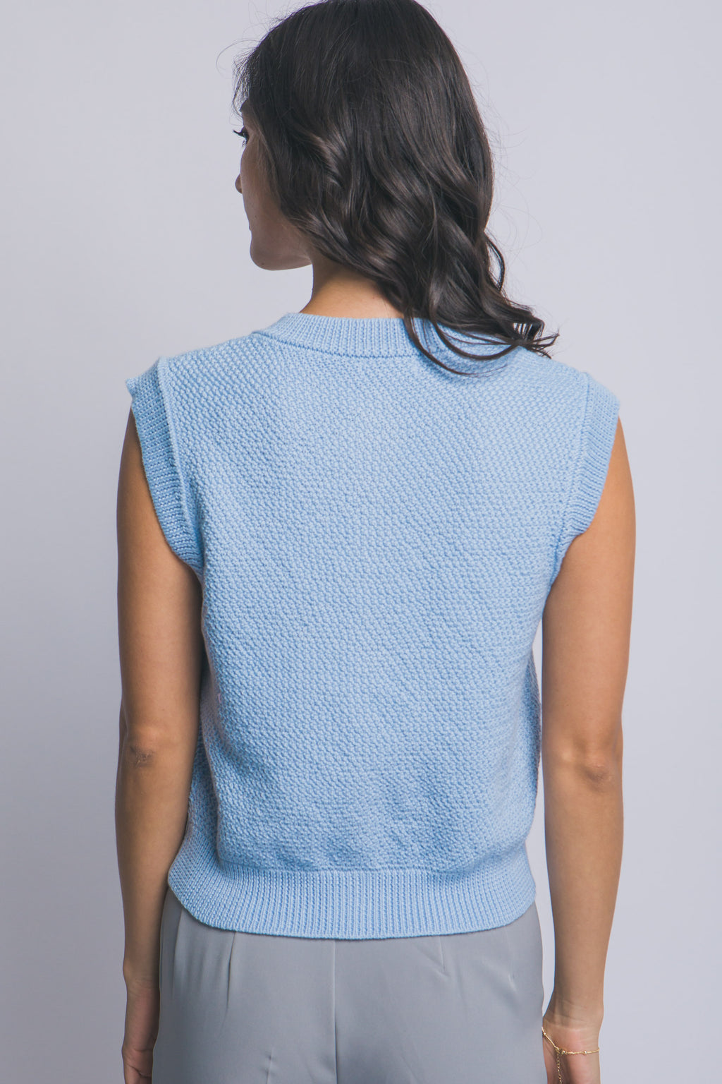 Suéter tejido sin mangas con botones decorativos dorados