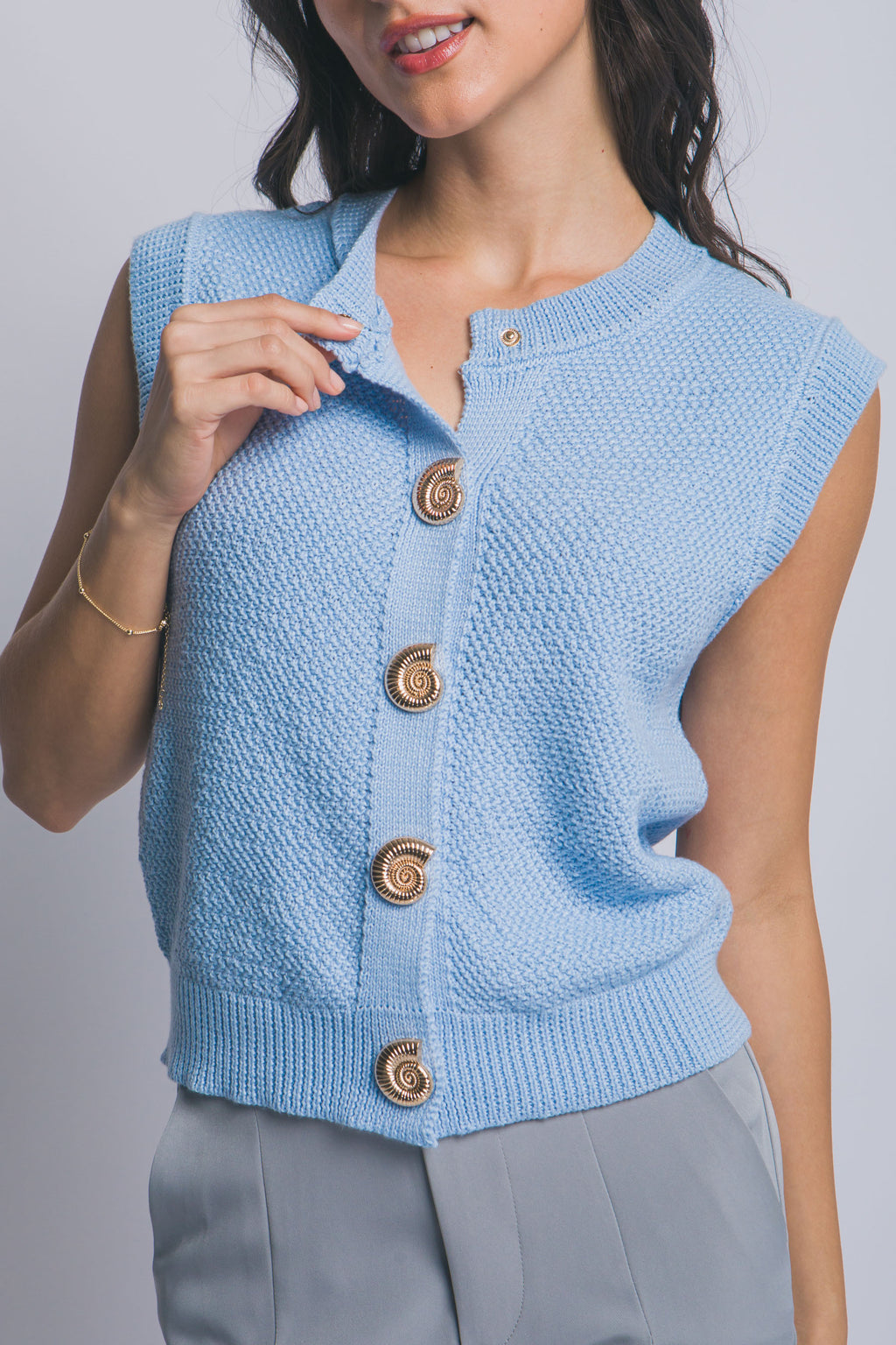 Suéter tejido sin mangas con botones decorativos dorados