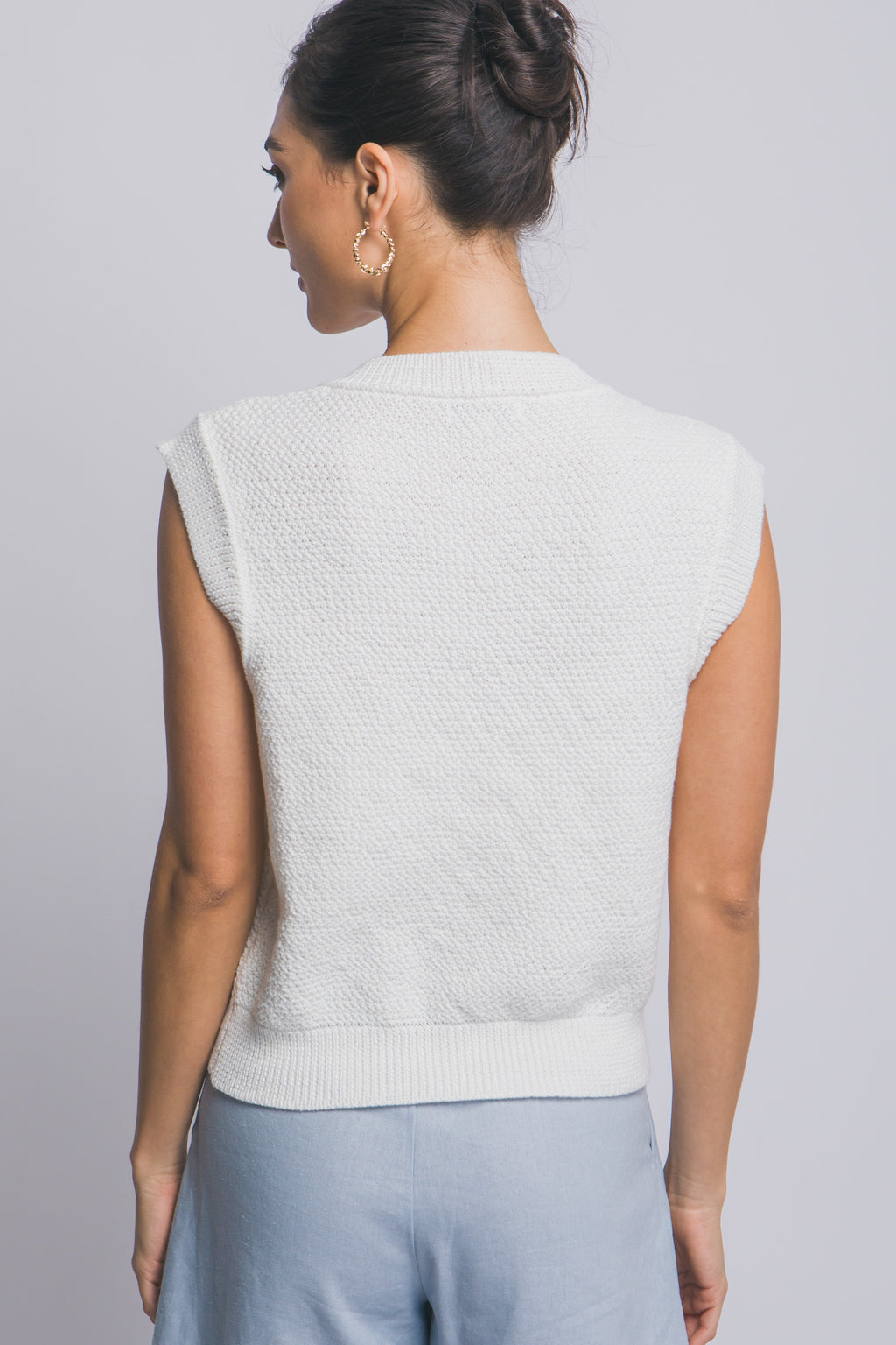 Suéter tejido sin mangas con botones decorativos dorados