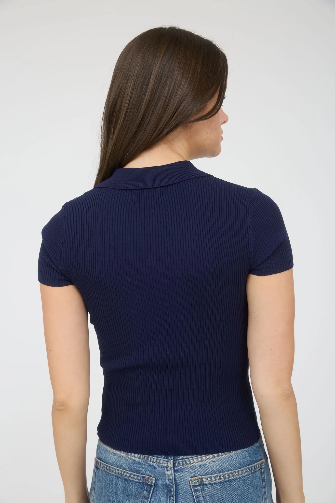 Blusa tipo polo stretch con botones dorados y textura acanalada