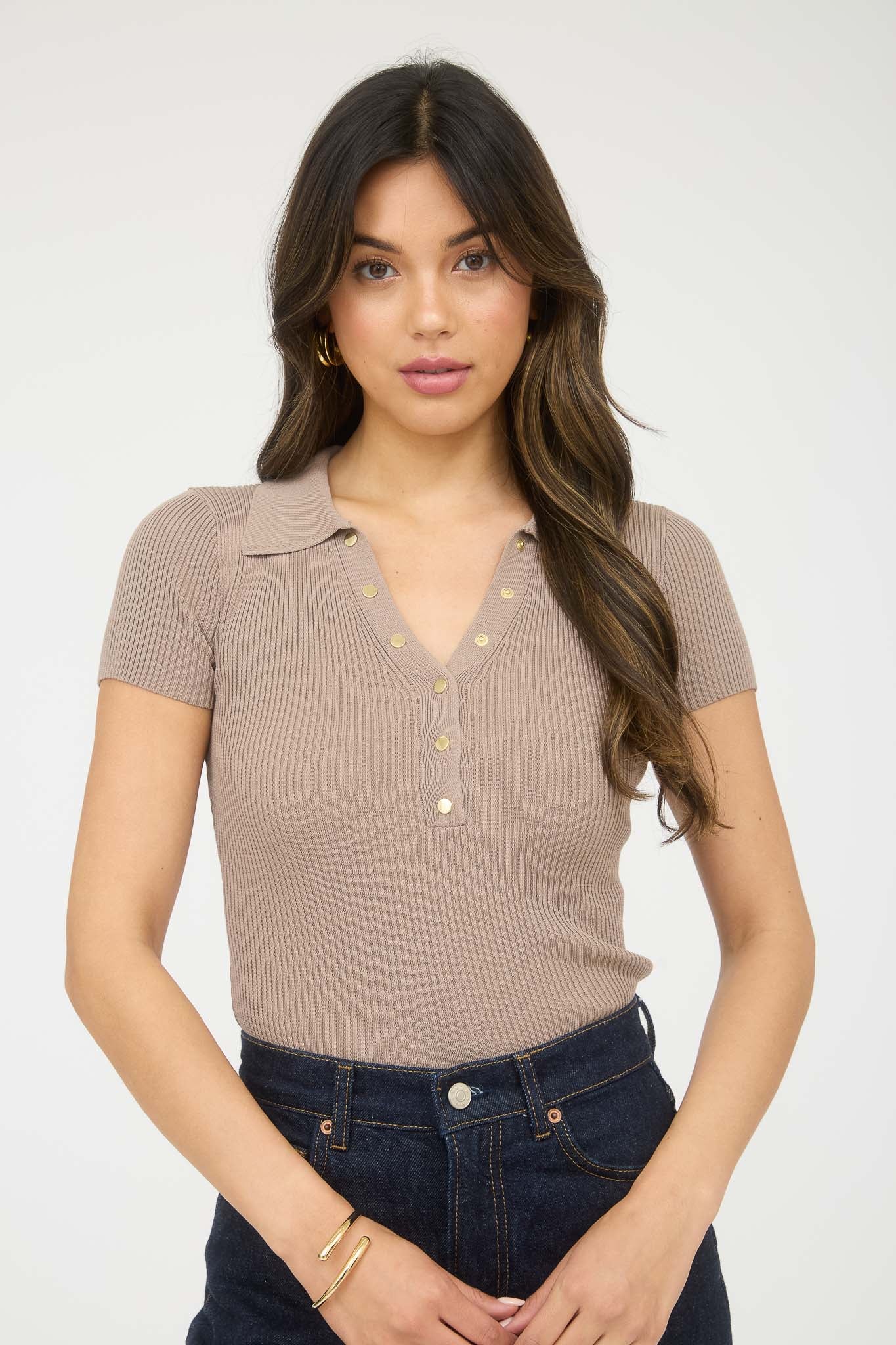 Blusa tipo polo stretch con botones dorados y textura acanalada